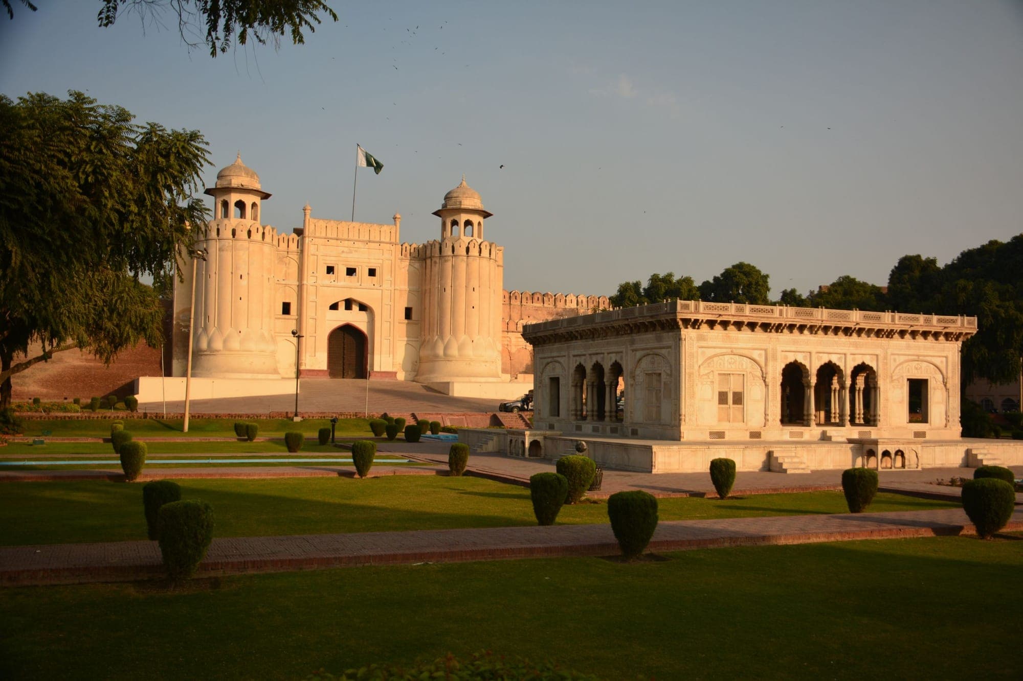 Lahore Fort Mughal architecture with maintained gardens in the foreground at sunset